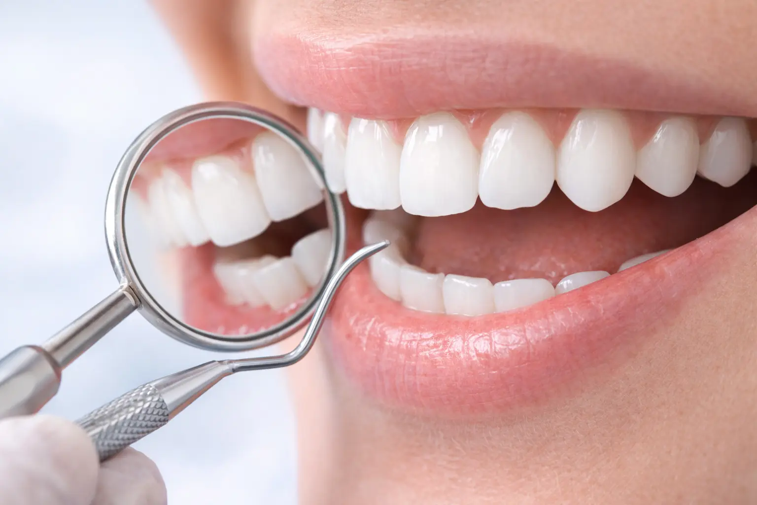 dentist examining teeth to check enamel health and sensitivity